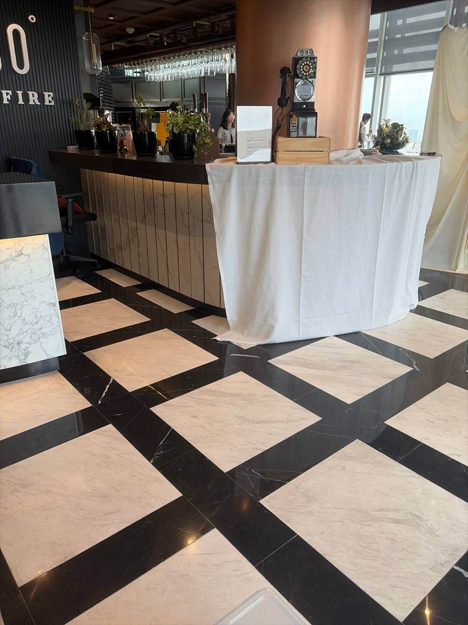 A black retro payphone guestbook on a white-draped counter at a restaurant event